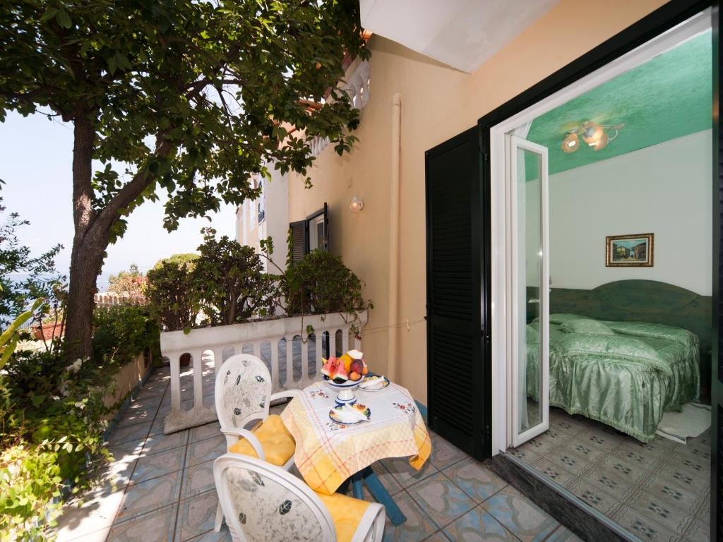 un patio avec une table, des chaises et un lit dans l'établissement Hotel Giardino Delle Ninfe E La Fenice, à Ischia 80 autres photos