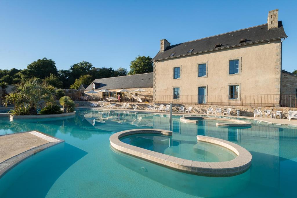 une grande piscine avec un bâtiment en arrière-plan dans l'établissement Camping de l'Orangerie de Lanniron, à Quimper