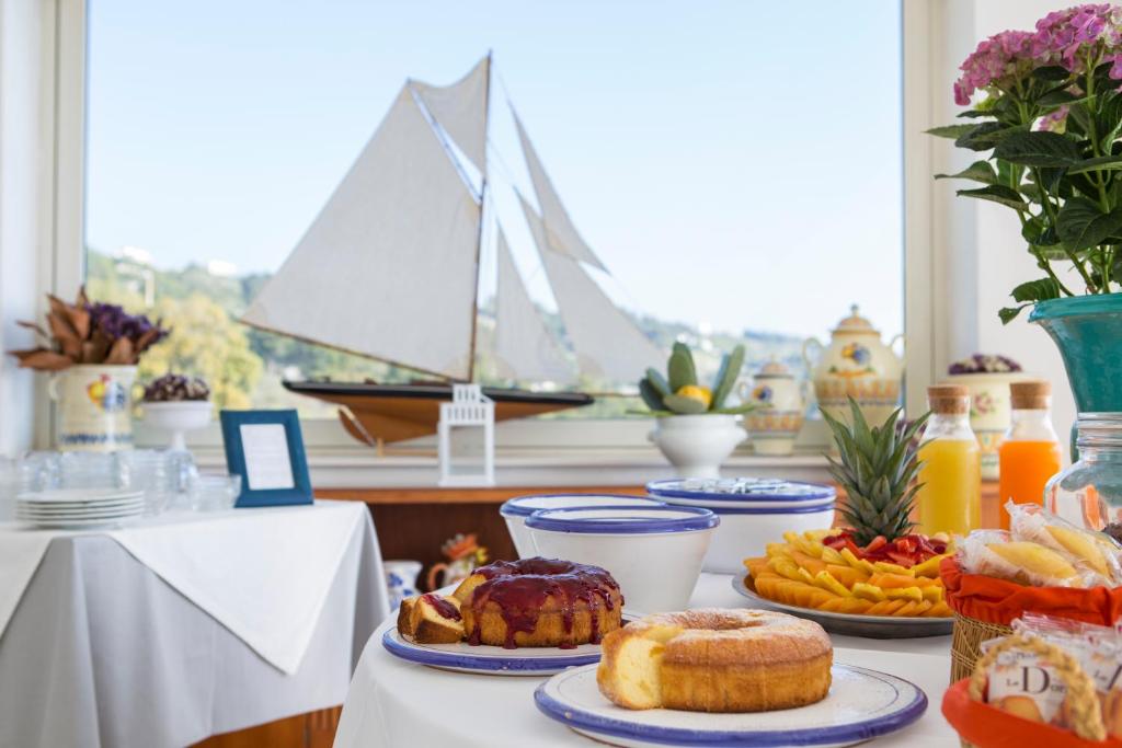 une table avec des assiettes de nourriture sur une table avec un bateau dans l'établissement Hotel Piccolo Mondo, à Castro di Lecce 58 autres photos