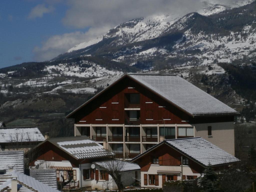 un lodge de ski avec des montagnes enneigées en arrière-plan dans l'établissement Les Serintes, à Saint-Léger-les-Mélèzes