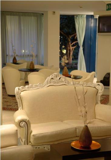 un salon avec un canapé blanc et des chaises dans l'établissement Hotel Aristeo, à Rimini