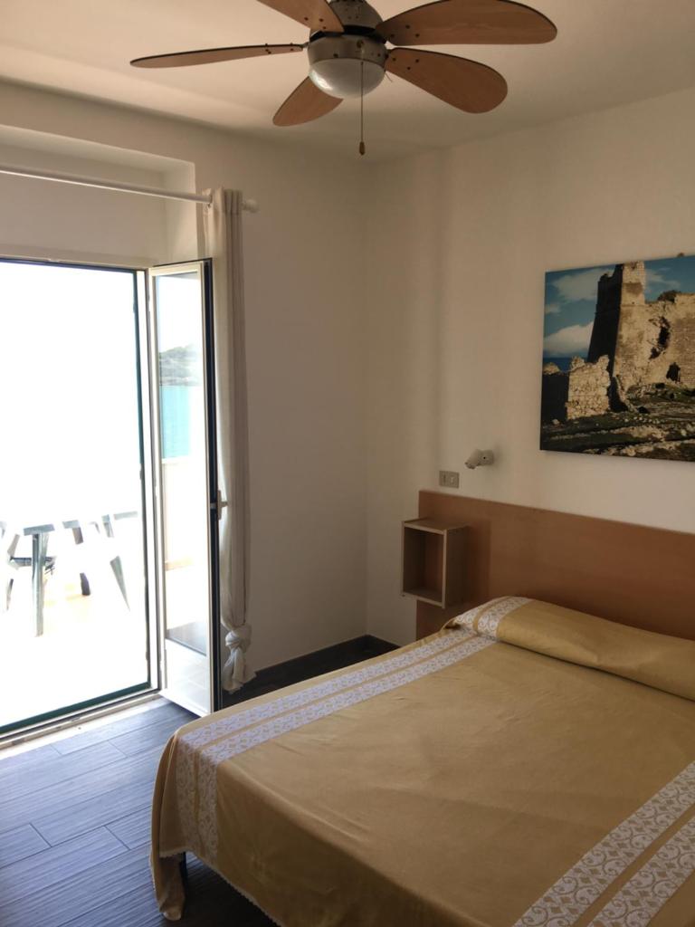 une chambre avec un lit et un ventilateur de plafond dans l'établissement Residence M3, à Peschici