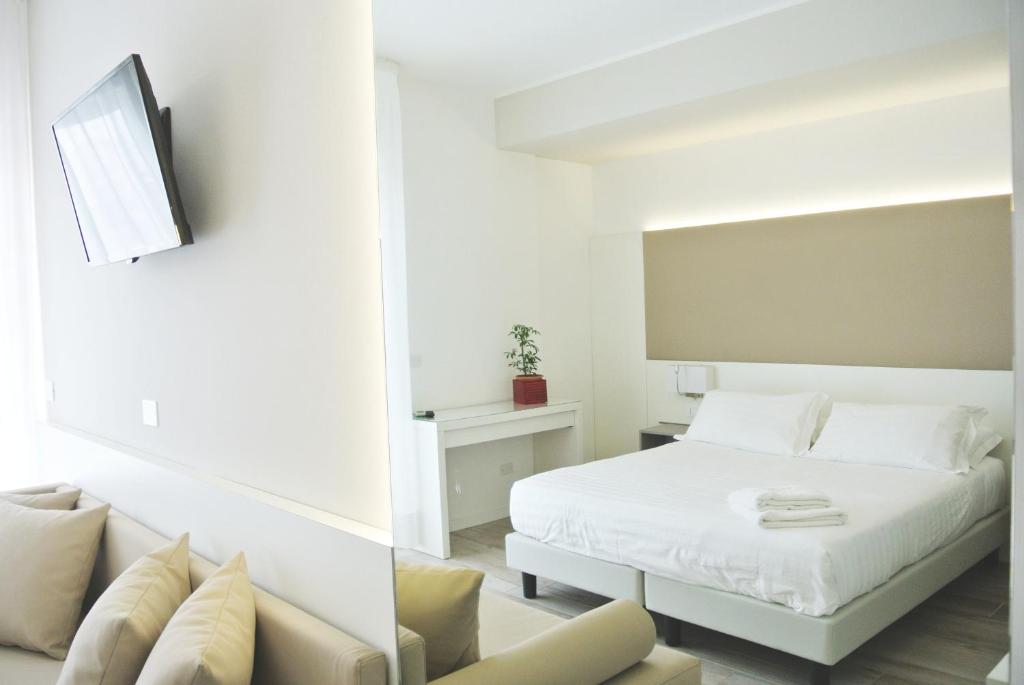- une chambre blanche avec un lit et un canapé dans l'établissement Hotel Bologna, à Lignano Sabbiadoro 32 autres photos