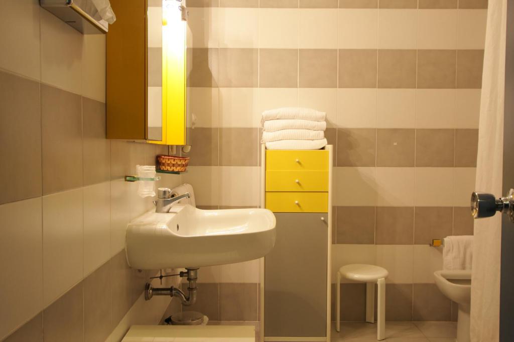 une salle de bain avec un lavabo et une armoire jaune dans l'établissement Grand Hotel Golf, à Tirrenia
