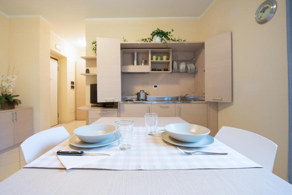 une table blanche avec deux bols dessus dans une cuisine dans l'établissement Residence Colombo, à Viareggio 80 autres photos
