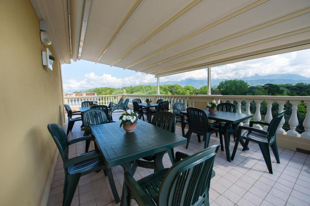 un patio avec tables et chaises sur un balcon dans l'établissement Residence Colombo, à Viareggio