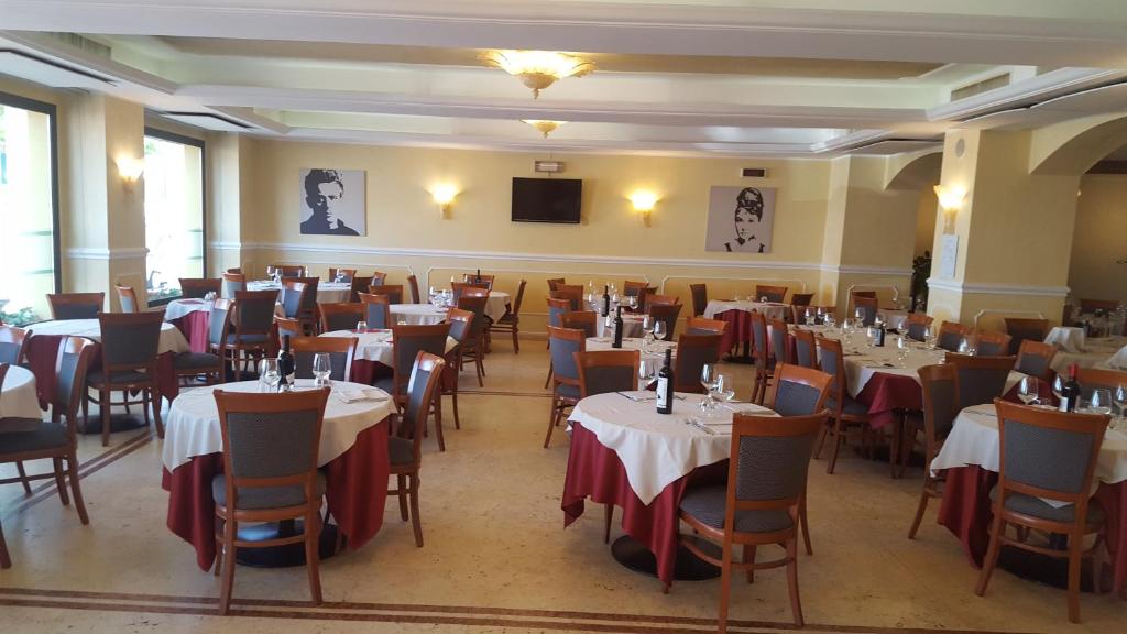 un restaurant avec des tables et des chaises dans une salle dans l'établissement Hotel Corallo, à Francavilla al Mare
