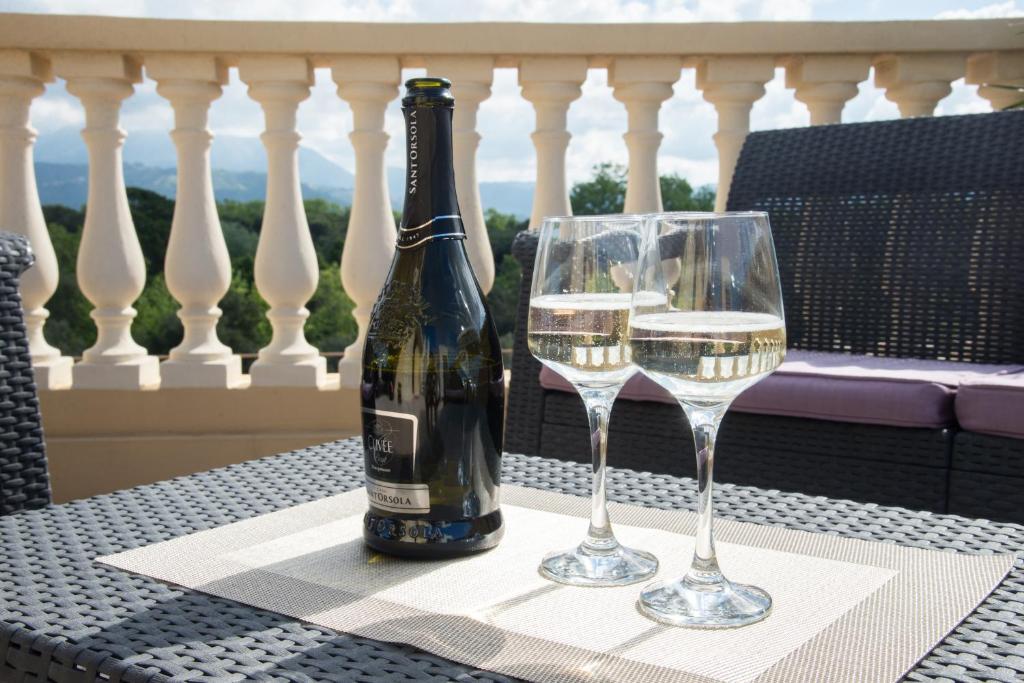 une bouteille de vin et deux verres sur une table dans l'établissement Residence Colombo, à Viareggio