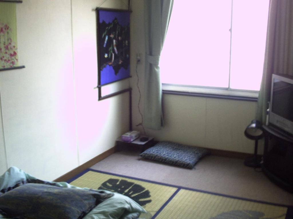 un salon avec une fenêtre et une télévision dans l'établissement Tama Ryokan, à Tokyo