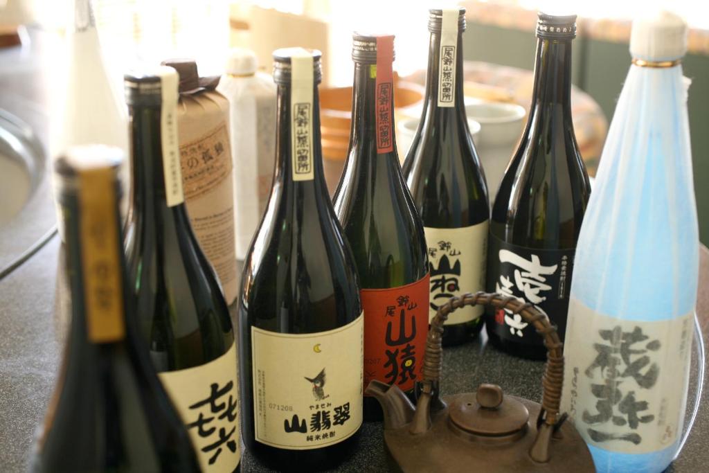 un groupe de bouteilles de vin sur un comptoir dans l'établissement Tabinoyado Ushionoakari Geiboso, à Shima