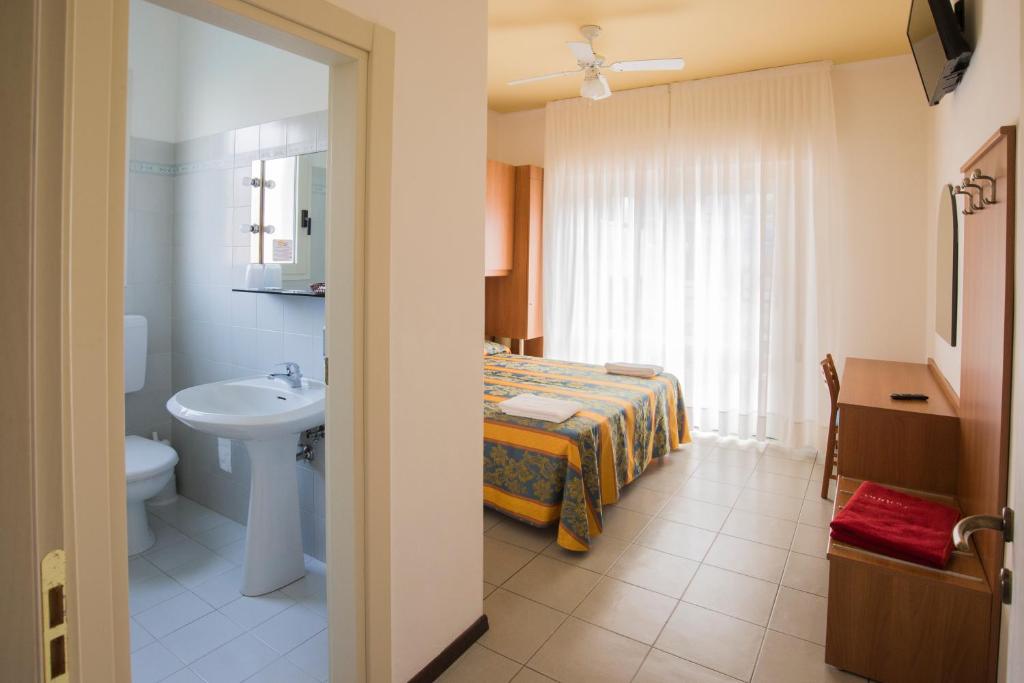 une salle de bain avec un lit, un lavabo et des toilettes dans l'établissement Pensione Villa Joli, à Lido di Jesolo