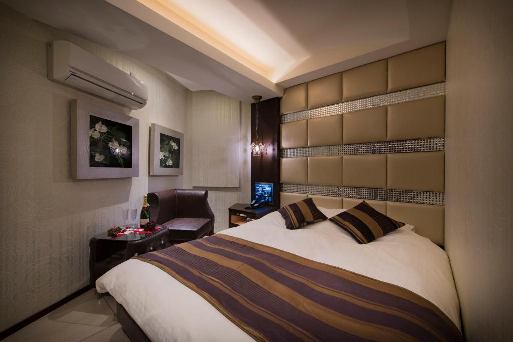 une chambre d'hôtel avec un lit et une chaise dans l'établissement Hotel Water Resort Sendai (Adult Only), à Sendai