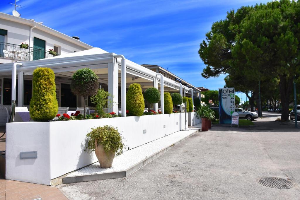 un bâtiment blanc avec des plantes sur son côté dans l'établissement Hotel Ristorante Fortuna, à Cavallino-Treporti