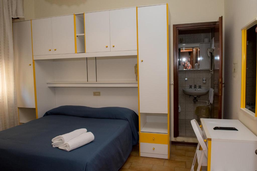 une petite chambre avec un lit et un lavabo dans l'établissement Hotel Malibran, à Lido di Jesolo