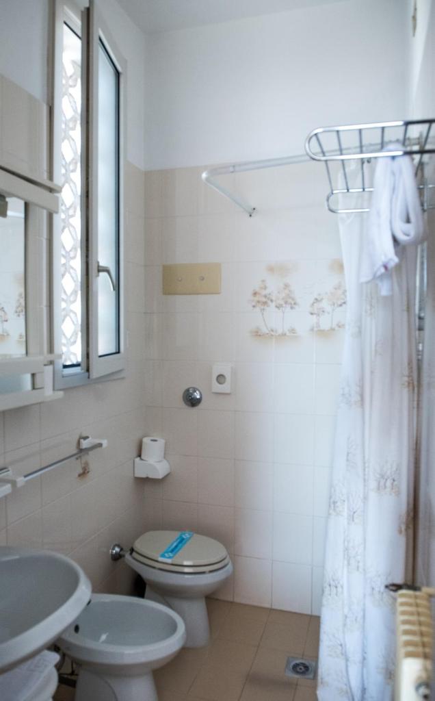 une salle de bain blanche avec toilettes et lavabo dans l'établissement Hotel Malibran, à Lido di Jesolo 56 autres photos