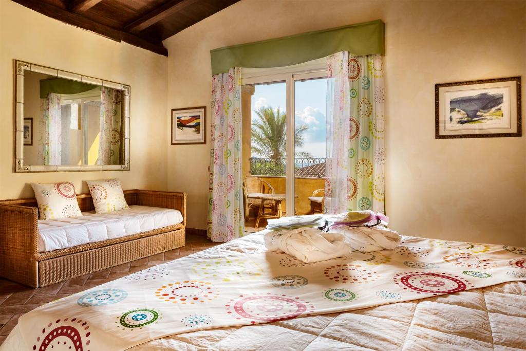 une chambre avec un grand lit et une fenêtre dans l'établissement Cruccùris Resort - Adults Only, à Villasimius