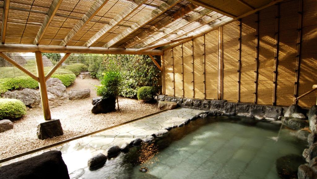 une piscine d'eau dans un bâtiment avec toit dans l'établissement Kasugai View Hotel, à Fuefuki