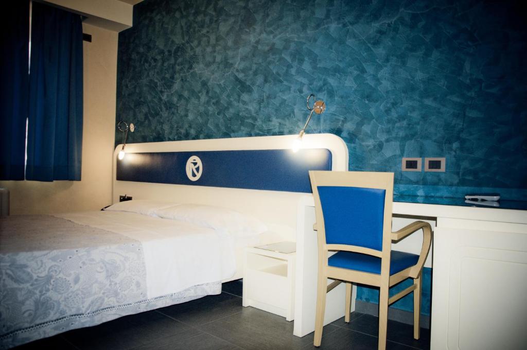 une chambre avec un lit blanc et un mur bleu dans l'établissement Aerhotel Phelipe, à SantʼEufemia Lamezia