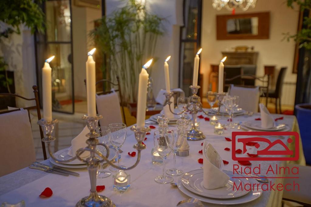une table avec des bougies, des assiettes et des verres dans l'établissement Riad Alma, à Marrakech 37 autres photos