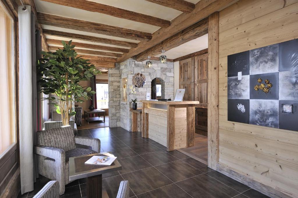- un salon avec des murs en bois, une table et un comptoir dans l'établissement CGH Résidences & Spas Le Jhana, à Tignes