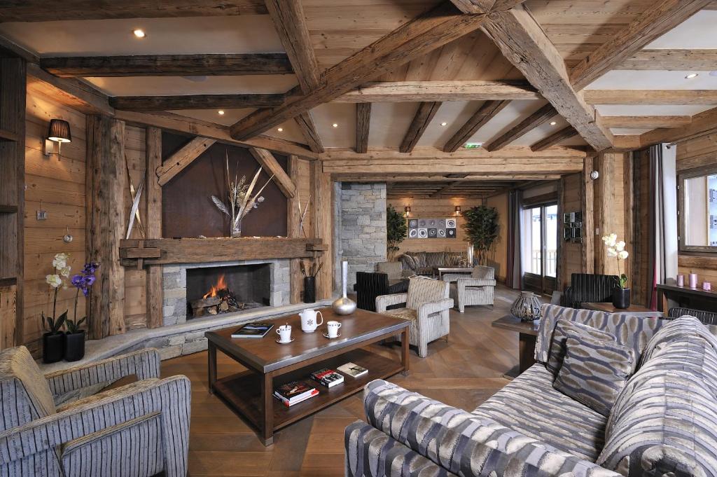 un salon avec des canapés et une cheminée dans l'établissement CGH Résidences & Spas Le Jhana, à Tignes