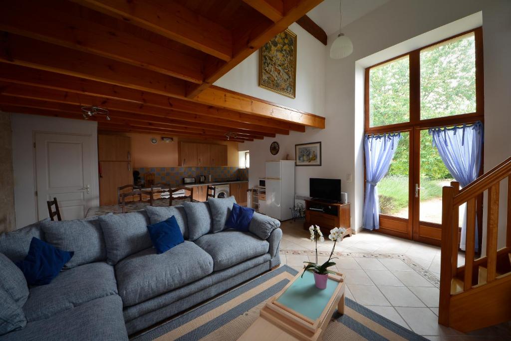 un salon avec un canapé bleu et une cuisine dans l'établissement Gites dans les Champs, à Sauzé-Vaussais