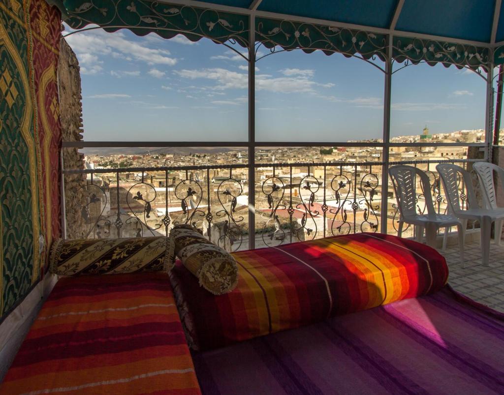Ce lit se trouve dans un dortoir doté d'un balcon avec vue. dans l'établissement Riad Diwan, à Fès