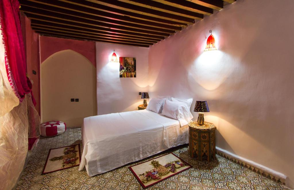- une chambre avec un lit blanc et deux lampes dans l'établissement Riad Diwan, à Fès