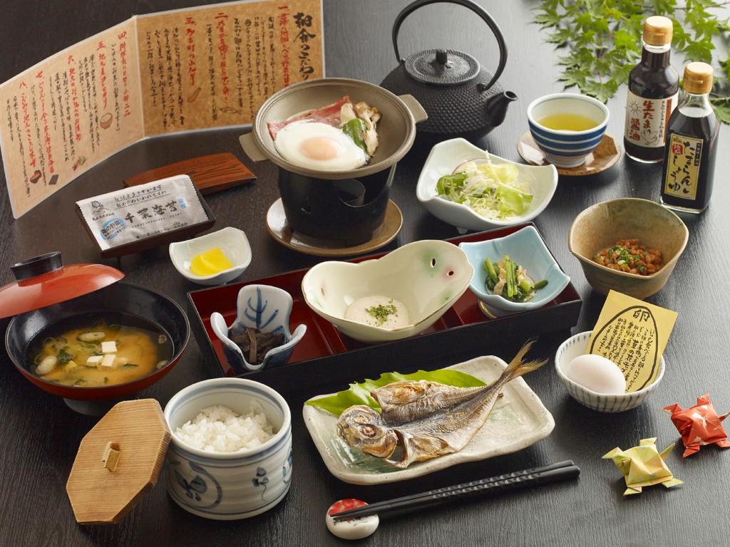 une table avec divers plats dessus dans l'établissement Kameyama Onsen Hotel, à Kimitsu 204 autres photos