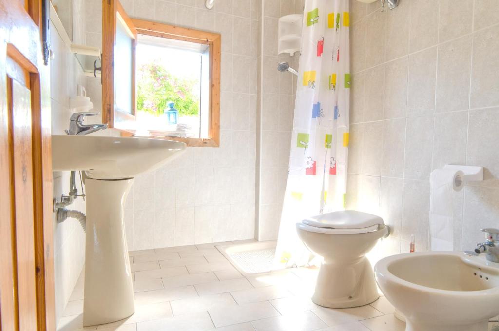 une salle de bain avec un lavabo et des toilettes et une fenêtre dans l'établissement Residence Albatros, à Briatico