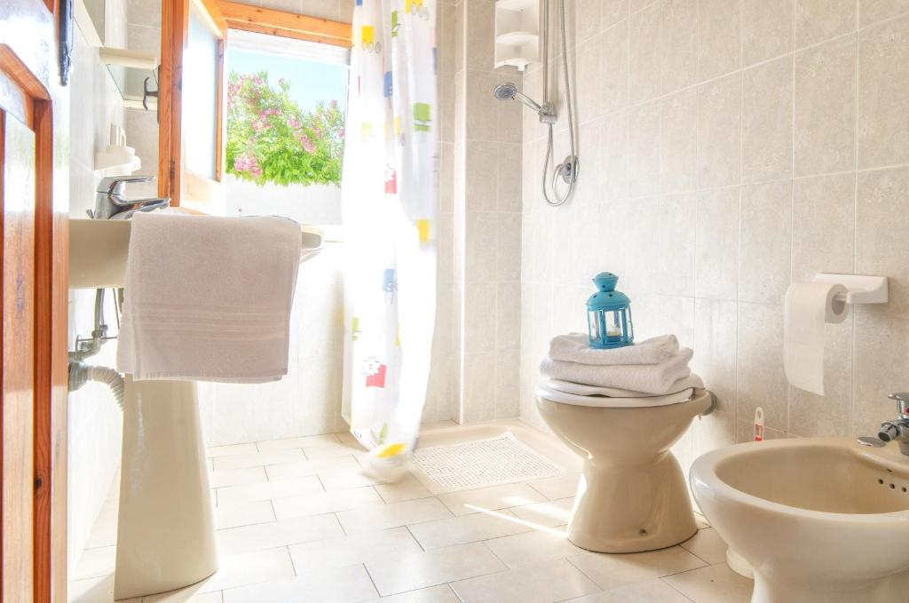 une salle de bain blanche avec toilettes et lavabo dans l'établissement Residence Albatros, à Briatico
