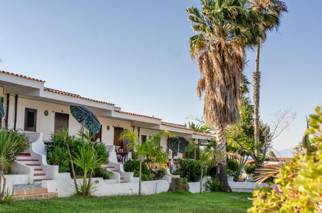 une maison avec des palmiers devant dans l'établissement Residence Albatros, à Briatico