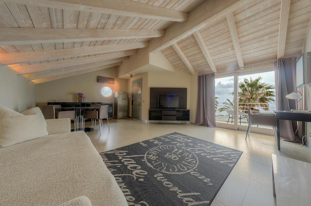 - un salon avec un canapé et une table avec une cuisine dans l'établissement Hotel De La Plage, à Pietra Ligure