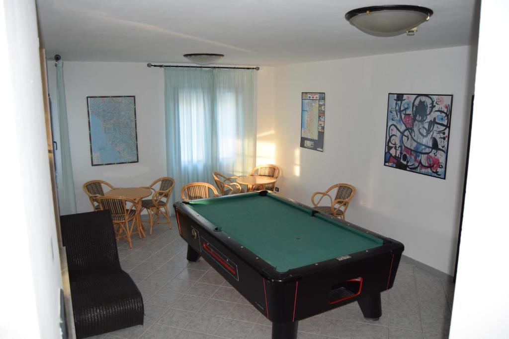 un salon avec une table de billard et des chaises dans l'établissement Orchidea Marina, à Tirrenia