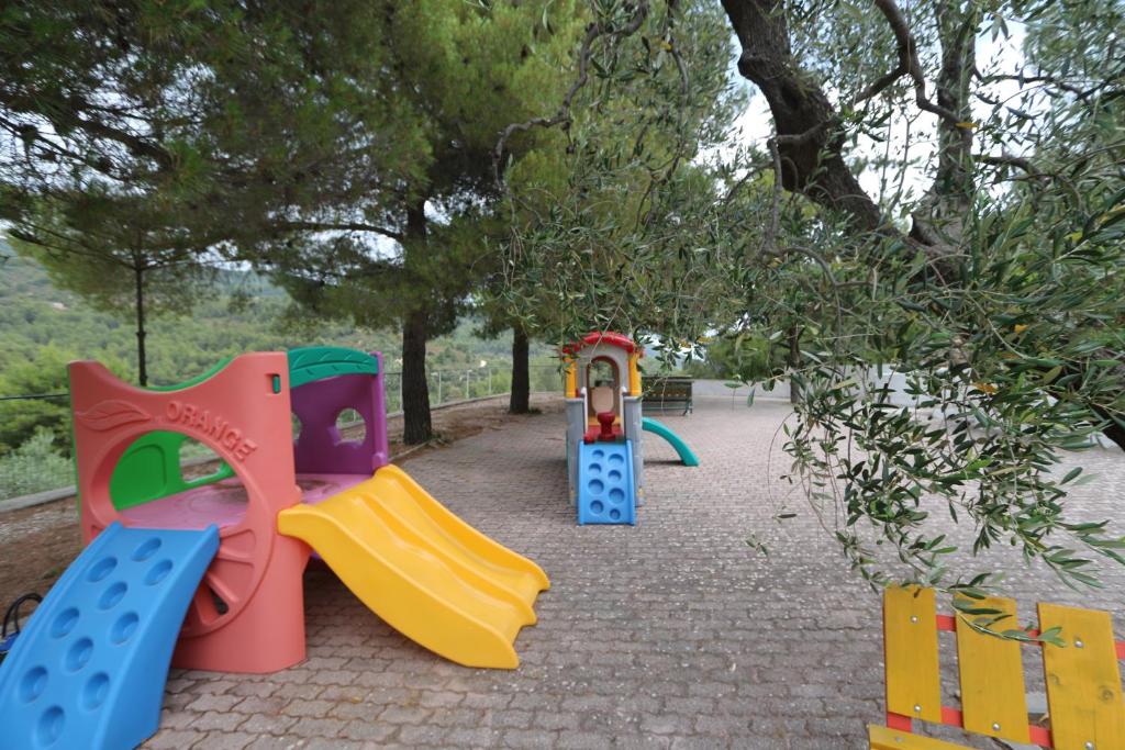 une aire de jeux avec des équipements de jeu colorés dans un parc dans l'établissement Camping Apartment Vignanotica, à Mattinata
