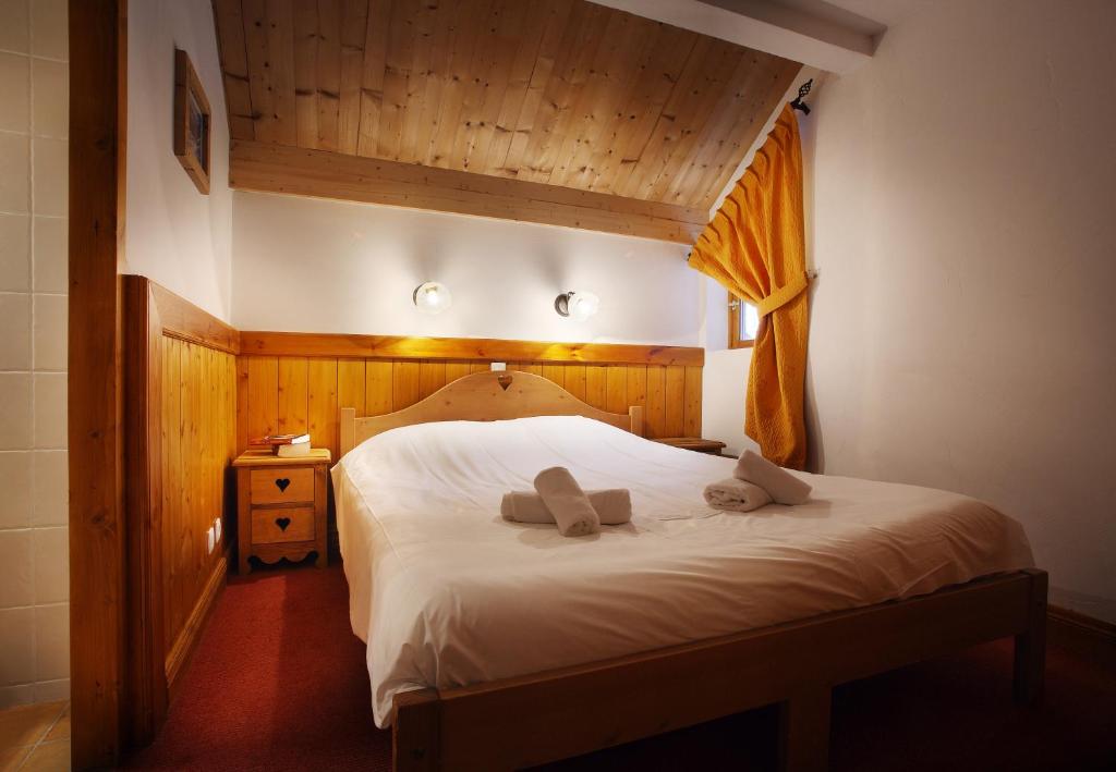 une chambre avec un lit avec deux oreillers dessus dans l'établissement Chalet des Neiges Oz en Oisans, à Oz 37 autres photos
