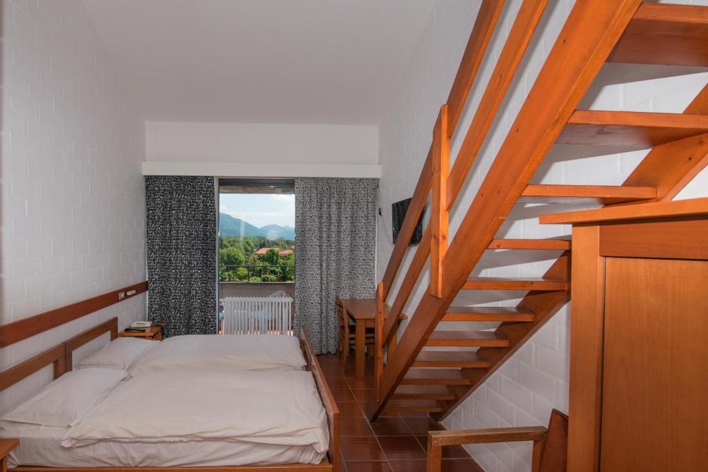 - une chambre avec un lit et un escalier avec une fenêtre dans l'établissement Hotel Campagna, à Cannobio