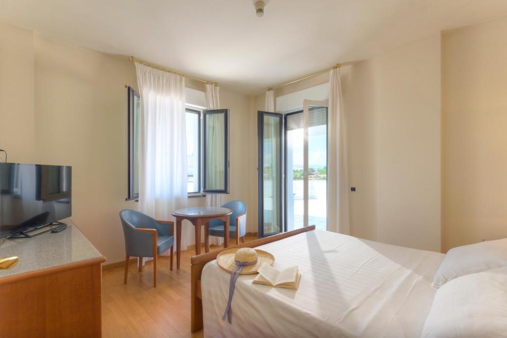 une chambre d'hôtel avec un lit, une table et des chaises dans l'établissement Hotel Il Timone, à Porto San Giorgio