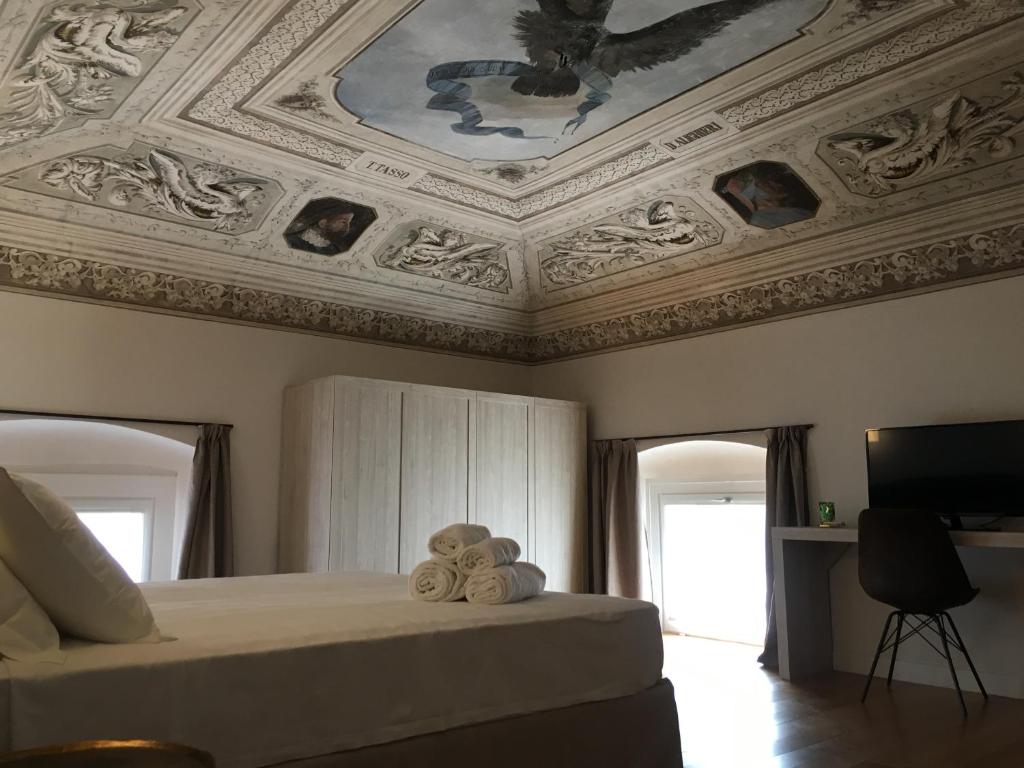 - une chambre dotée d'un plafond avec un lit et une télévision dans l'établissement Hotel Palazzo Vannoni, à Levanto