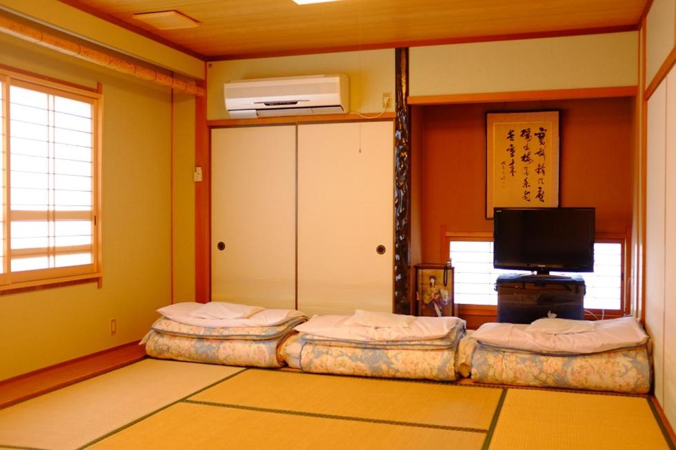 Cette chambre comprend 2 lits jumeaux et une télévision. dans l'établissement Mizuhokan, à Ise