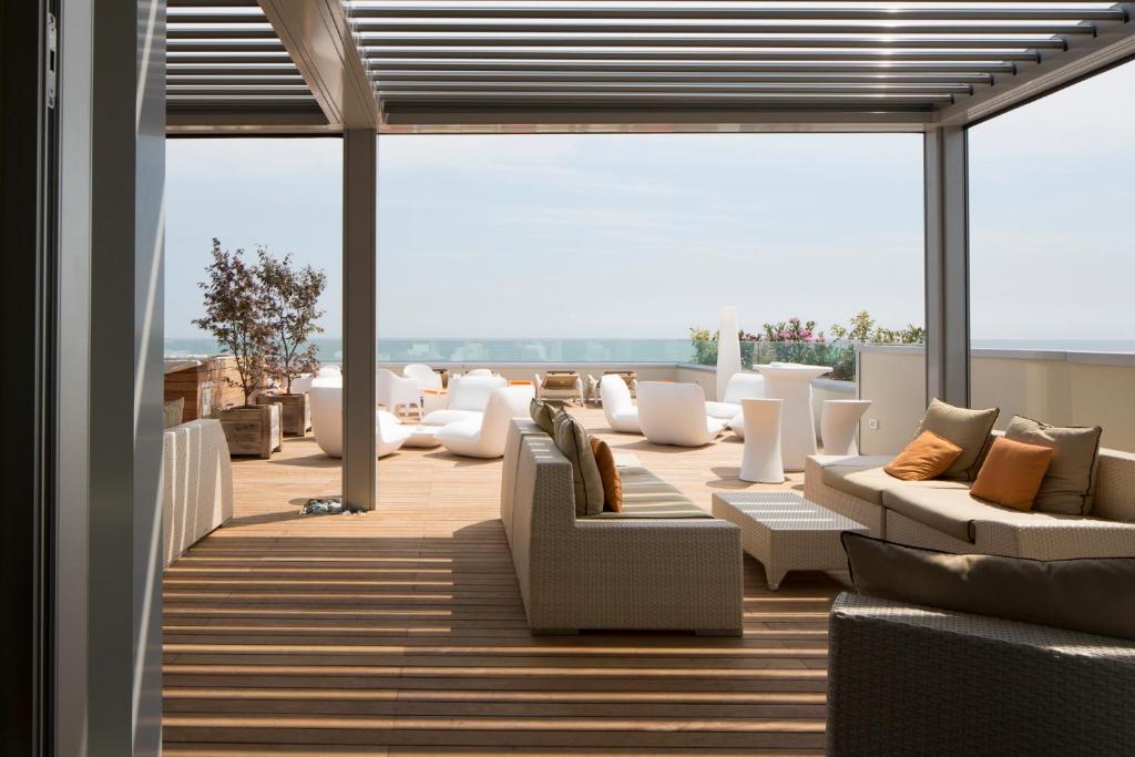 - un salon avec des canapés et des chaises sur le toit dans l'établissement Hotel Ambassador, à Bibione