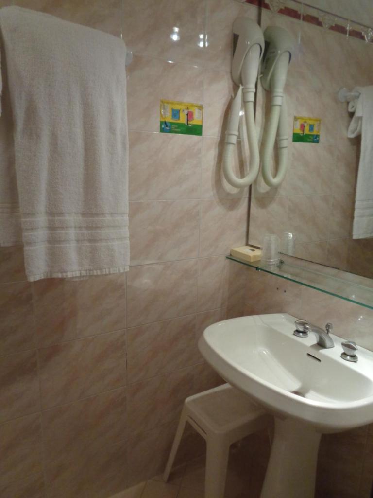 La salle de bains est pourvue d'un lavabo, d'un miroir et d'une serviette. dans l'établissement Hotel Continental, à Lido di Jesolo 66 autres photos