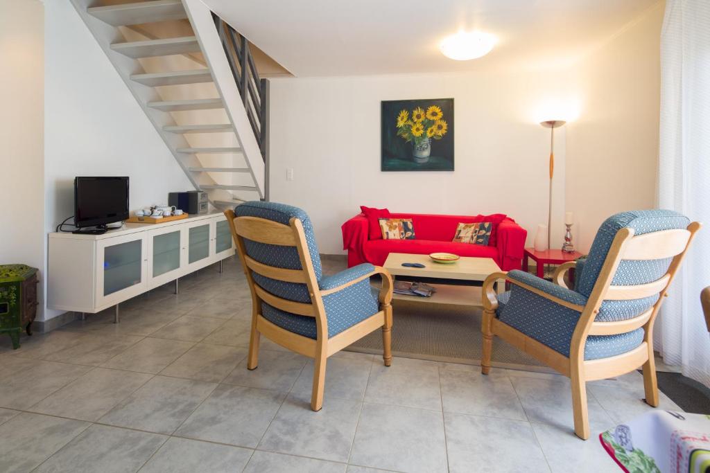 - un salon avec un canapé et des fauteuils rouges dans l'établissement Gîte le Noyer - l'Ancien Vignoble, à Saint-Julien-de-Lampon