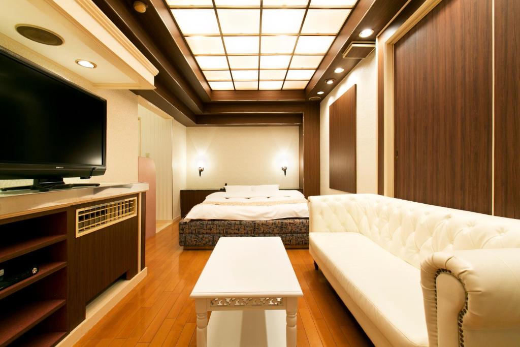 un salon avec un canapé et une télévision à écran plat dans l'établissement Hotel Luna (Adult Only), à Sennan