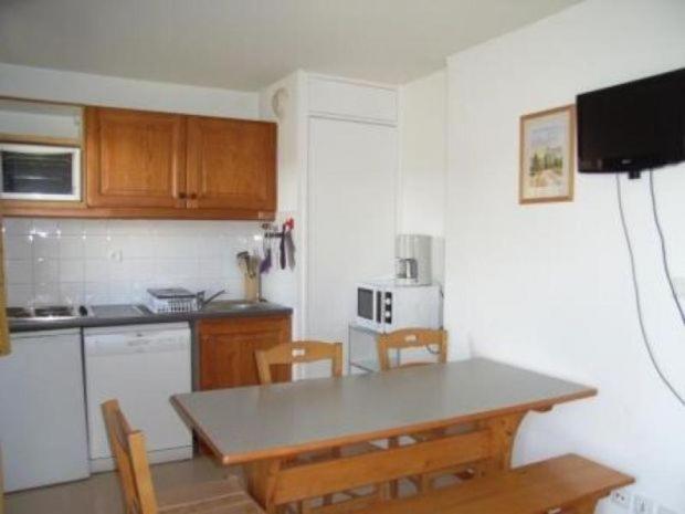 - une cuisine avec une table, une table et des chaises dans l'établissement ANCOLIE 23 Les Chalets de Super D, à Saint-Étienne-en-Dévoluy