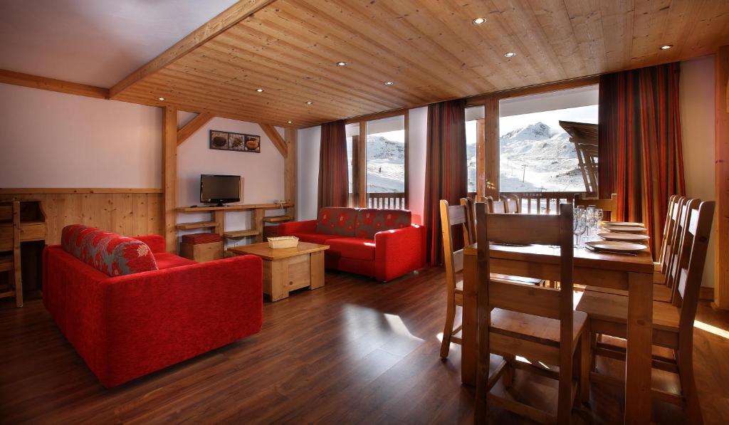un salon avec un canapé rouge et une table dans l'établissement Chalet des Neiges : La Cime Des Arcs, à Arc 2000