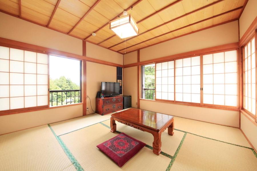 - un salon avec une table basse et des fenêtres dans l'établissement Minshuku Fukufuji, à Nikkō