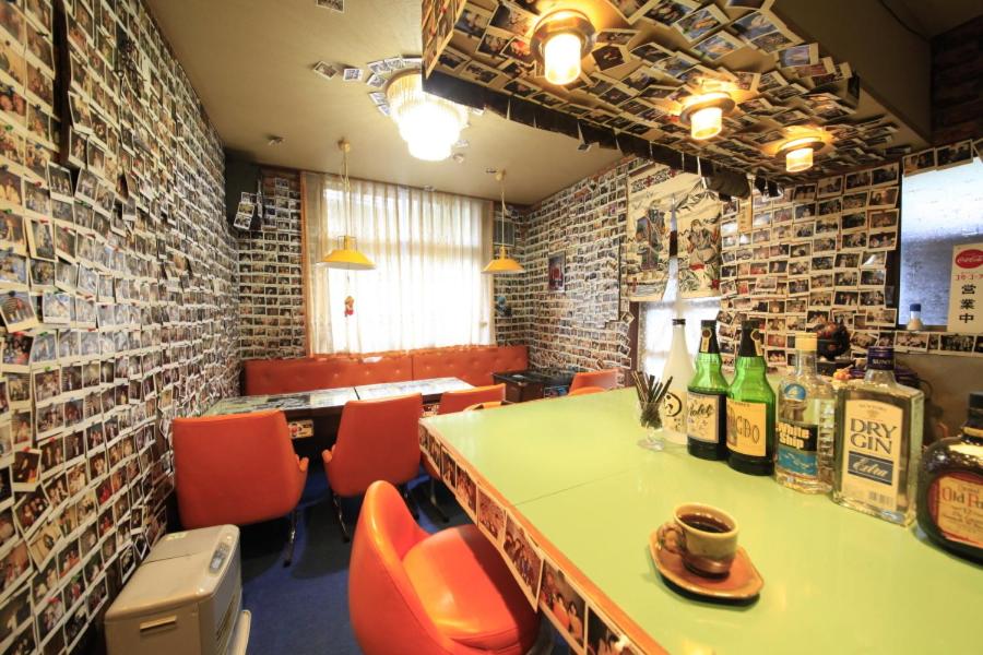 - un restaurant avec une table, des chaises et des bouteilles de vin dans l'établissement Minshuku Fukufuji, à Nikkō 37 autres photos