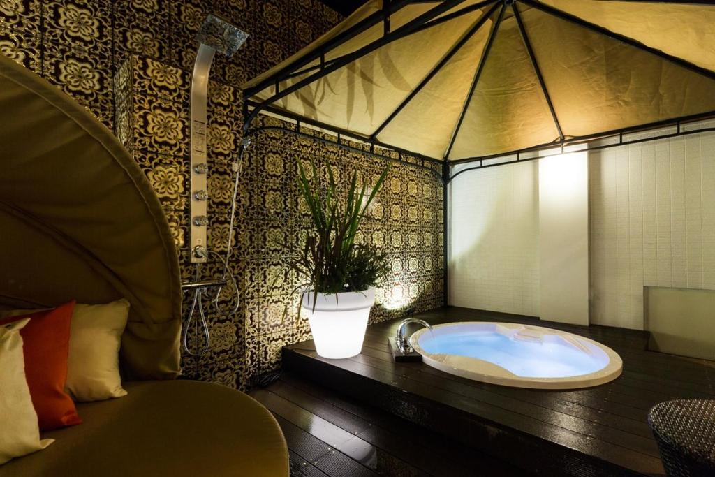une salle de bain avec une baignoire sur une table avec une plante dans l'établissement Hotel CLover Leaf Tsukasa (Love Hotel), à Tosu