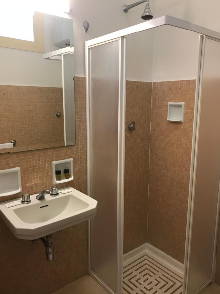 une salle de bain avec douche et lavabo dans l'établissement Hotel Mediterranée, à Taormine